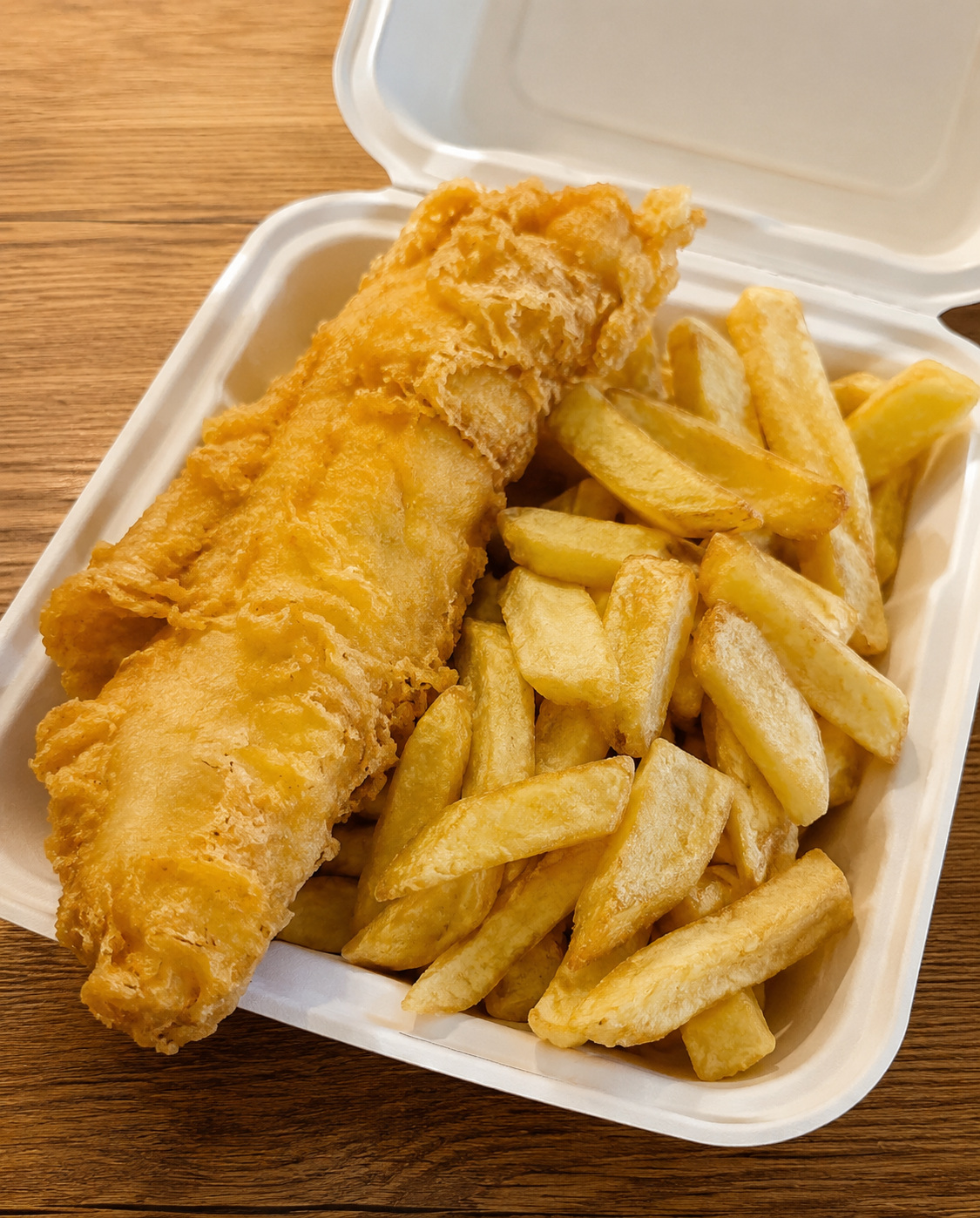 Golden battered fish and chips served fresh in a takeaway box